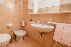 a bathroom with a sink and a toilet at Happy Guest Apartments - Pink Mountain Presolana in Castione della Presolana