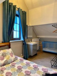 a bedroom with a bed and a sink and a window at The Charm in Bouillon