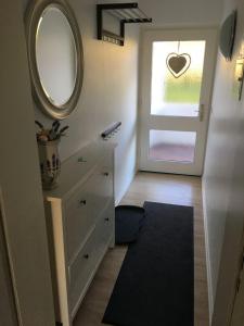 Zimmer mit einer Kommode und einer Tür mit einem Spiegel in der Unterkunft Wohnung Nr. 1 Willingen in Willingen