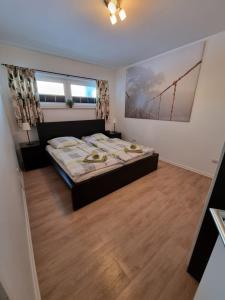 een slaapkamer met een groot bed en een houten vloer bij Wohnung Nr. 1 Willingen in Willingen