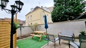 a patio with a table and chairs and an umbrella at Bulles de sommeil - Cozy - RBNB in Mulhouse