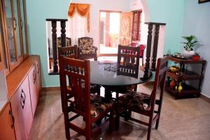 a dining room with a table and chairs at Holidayincoorg Royal Mansion in Madikeri +28 photos