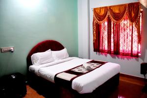 a bedroom with a bed with a red window at Holidayincoorg Royal Mansion in Madikeri