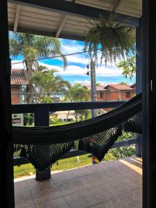 una hamaca en un porche con vistas al océano en Off hostel floripa en Florianópolis
