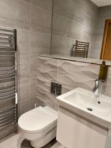 bagno con servizi igienici bianchi e lavandino di Royal Golf Apartments a Dornoch