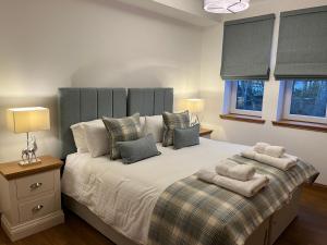 1 dormitorio con 1 cama grande y 2 almohadas en Royal Golf Apartments en Dornoch
