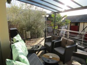 d'une terrasse avec des canapés et des chaises sur un balcon. dans l'établissement Chambre d'hôtes Au Nid du Thil, à Beauvais