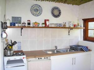 cocina con fregadero, fogones y platos en la pared en Oltmans farm stay, en De Rust