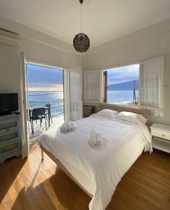 a bedroom with a large bed with a view of the ocean at Thassa Beach Apartment No4 in Leonidion