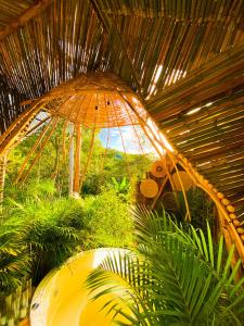 un grande ombrello di paglia in una stanza con piante di Glamping CAVE a Isnos