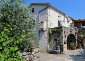a white building with an archway in a yard at Apartmani Purić in Malinska