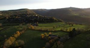 una vista aérea de un campo verde con una ciudad en Maison d'Hôtes La Grange, en Salers