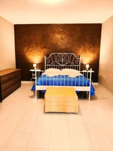 1 Schlafzimmer mit einem blauen Bett und 2 Tischen in der Unterkunft TermeSele 'Al vico' Apartment Contursi Terme in Contursi Terme