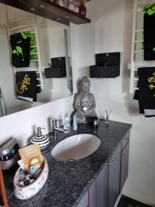 a bathroom with a sink and a statue on a counter at Marsvinslund bed and breakfast in Viborg