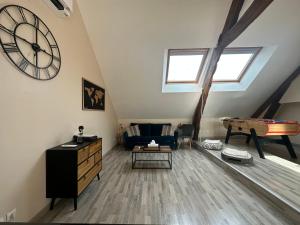 a living room with a large clock on the wall at La Maison du Moulin à Vent in La ForestiÃ¨re