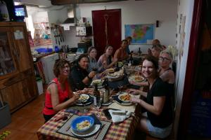 un grupo de personas sentadas en una mesa comiendo comida en Albergue a Casina di Marcello en Palas de Rei 