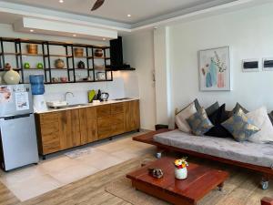 a living room with a couch and a kitchen at Puntakana Apartelle Spacious Apartment Panglao in Panglao