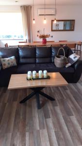 a living room with a black couch and a coffee table at Letnisko nad Gopłem in Skulsk