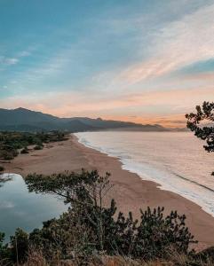 Blick auf den Strand bei Sonnenuntergang in der Unterkunft Kitnetes & Aptos Praia do Capricórnio in Caraguatatuba