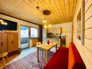 a kitchen and dining room with a wooden ceiling at Apart Samnaun in Ischgl