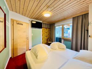 een hotelkamer met een bed met twee witte kussens bij Apart Samnaun in Ischgl