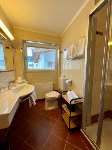 een badkamer met een wastafel en een toilet en een raam bij Apart Samnaun in Ischgl