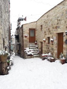 un edificio de piedra con nieve en el suelo en Verso Est, en Petralia Soprana