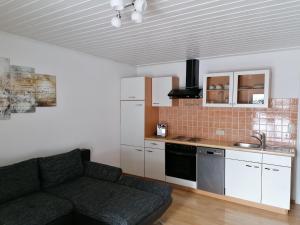 sala de estar con sofá y cocina en Landhaus Klausner en Saalbach Hinterglemm