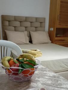 - un bol de fruits sur une table à côté d'un lit dans l'établissement Studio pêcheur, à Oualidia