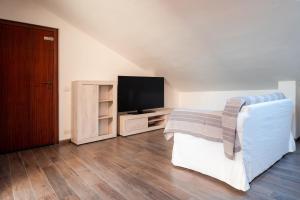 ein Wohnzimmer mit einem Bett und einem TV in der Unterkunft LA SOFFITTA DEI SOGNI 010059-LT-2481 in Sestri Levante