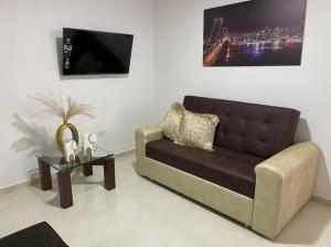 a living room with a brown couch and a table at Apartamento pitalito in Pitalito