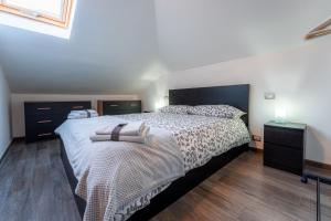ein Schlafzimmer mit einem großen Bett und Holzböden in der Unterkunft LA SOFFITTA DEI SOGNI 010059-LT-2481 in Sestri Levante
