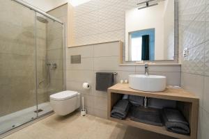 a bathroom with a sink and a shower and a toilet at Gli specchi di Archimede in Siracusa