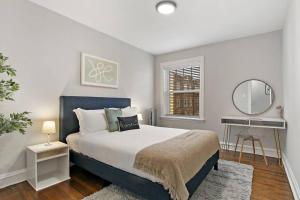 um quarto com uma cama grande e um espelho em Pleasant 2BR Apt with Furnished Kitchen - Troy 2 em Chicago