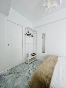 een witte kamer met een bed en een tafel bij Apartamento Torreón De La Huerta in Córdoba