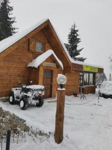 a snow covered atv parked in front of a building at Vikendica Čeperković #3 in Kopaonik