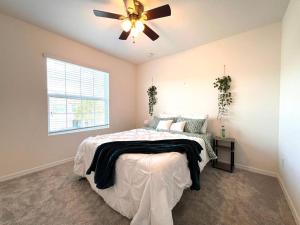 um quarto com uma cama e uma ventoinha de tecto em A Cozy Home Away From Home em Riverview
