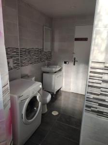 24 D-Habitacion en piso في سان فيسينتي ديل راسبيغ: حمام مع غسالة ملابس وغسالة