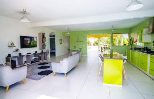 a kitchen with green cabinets and white tile floors at La Villa Soleil :) in Sainte-Anne