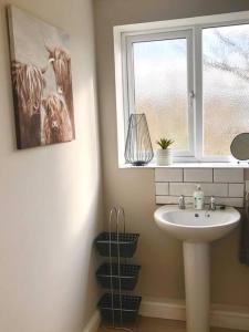 ein Bad mit einem Waschbecken und einem Fenster in der Unterkunft Harrow Hayloft Rural 80m2 Village Hideaway Retreat in Himbleton