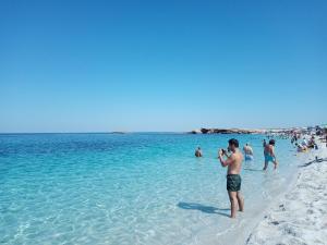 Un homme qui prend une photo des gens sur la plage dans l'établissement La casa di Gaia, à Cabras