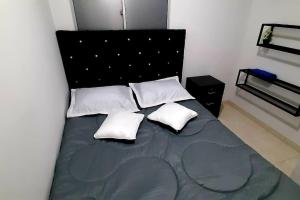 1 dormitorio con 1 cama con 2 almohadas en Apartamento en Cúcuta completó en condominio n8, en Cúcuta