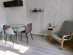 uma sala de jantar com uma mesa de vidro e cadeiras em Apartmán Hybešova em Brno