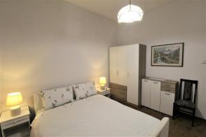 Un dormitorio con una cama blanca y dos lámparas. en Sea Balcony Apartment Savudrija, en Savudrija
