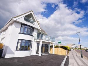 a white house with a balcony on a street at Panorama Apartment 1 - Uk40626 in Southbourne