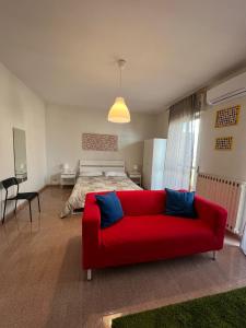 un soggiorno con divano rosso di fronte a un letto di Casa Vacanze Visit Puglia a Casamassima