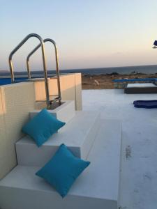 una panchina con cuscini blu seduta su un tetto di Sofia Villas Pounta Beach ad Afiartis