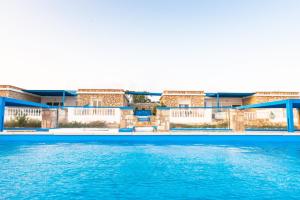 una piscina con acqua blu di fronte agli edifici di Sofia Villas Pounta Beach ad Afiartis