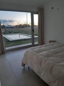 1 dormitorio con cama y vistas a la piscina en ELONCE en Balneario Claromecó