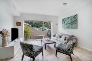 a living room with a couch and a tv at Barrenjoey at Iluka Resort Apartments in Palm Beach